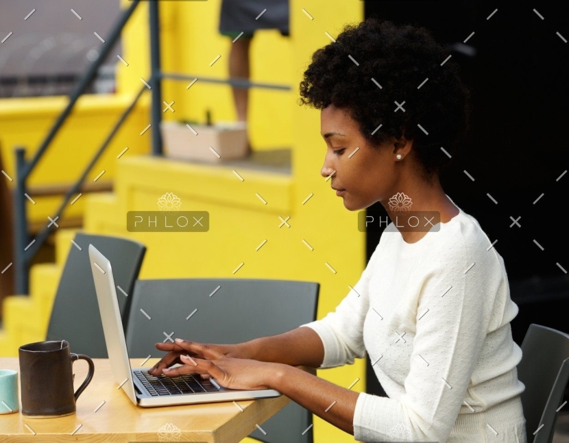 attractive-young-woman-using-laptop-outside-P9RLFGU@2x